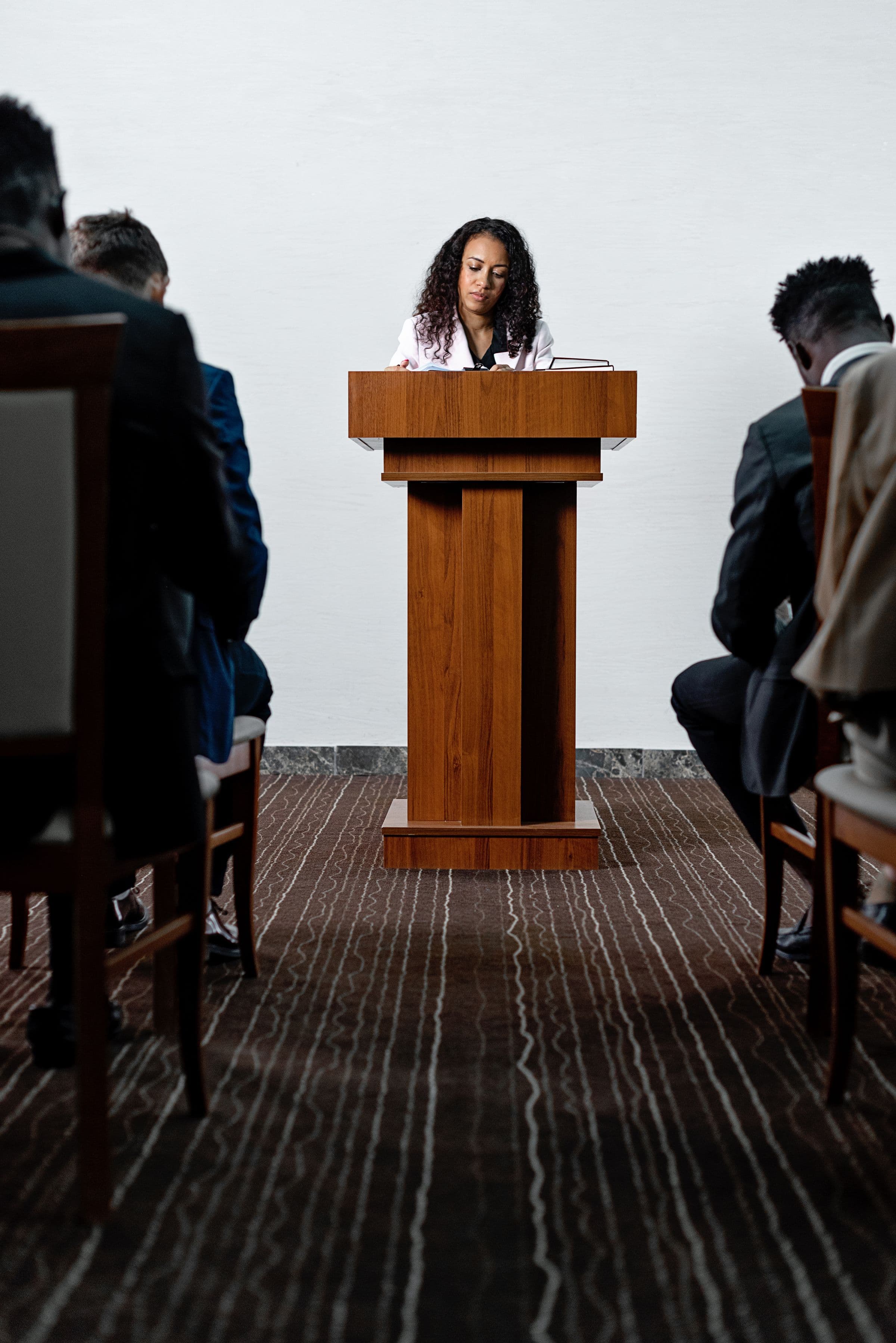 A speaker at a podium addressing a seated audience