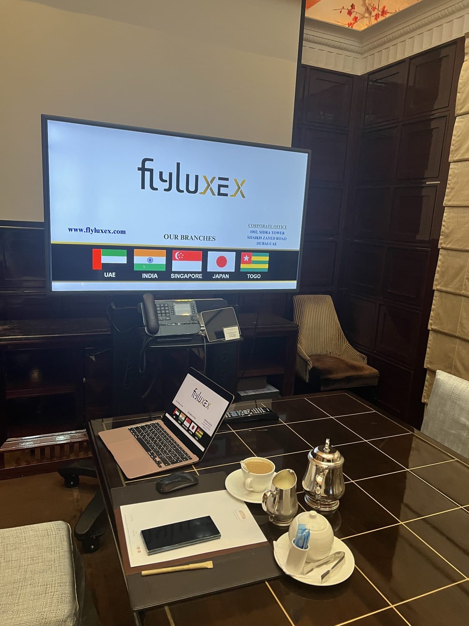 The Flyluxex branch network displayed on screen beside a traditional tea service