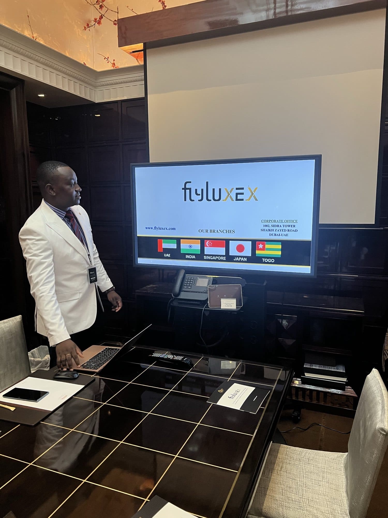 A Flyluxex representative in a white blazer reviewing the firm's branch presentation